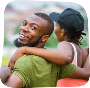A smiling man looks over his shoulder as a woman wraps her arm around him, capturing joy, connection, and community support. © CIVIC