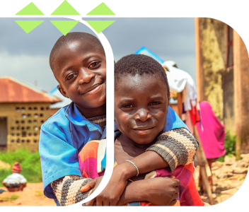 Two smiling children stand outside in a rural community, with one child’s arms wrapped warmly around the other, symbolizing friendship, resilience, and youth empowerment. Photo © CIVIC